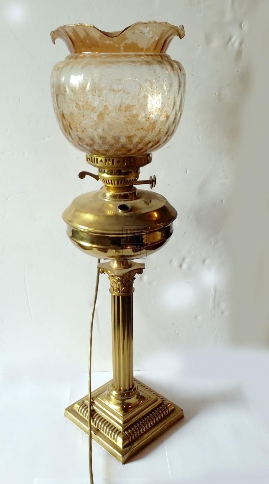 Ornate brass oil lamp with glass shade