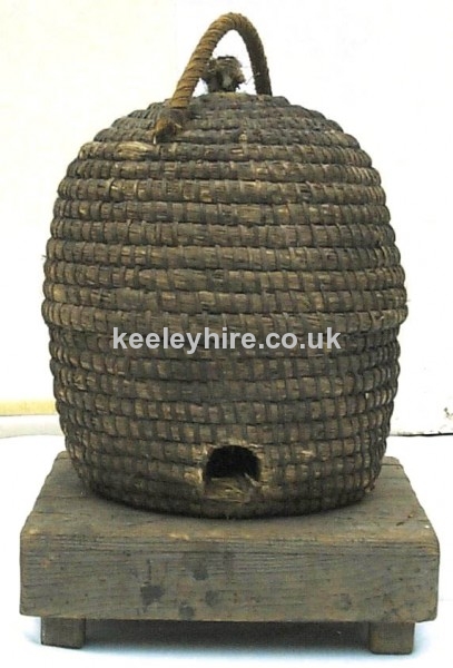Straw bee hive basket on low wood table
